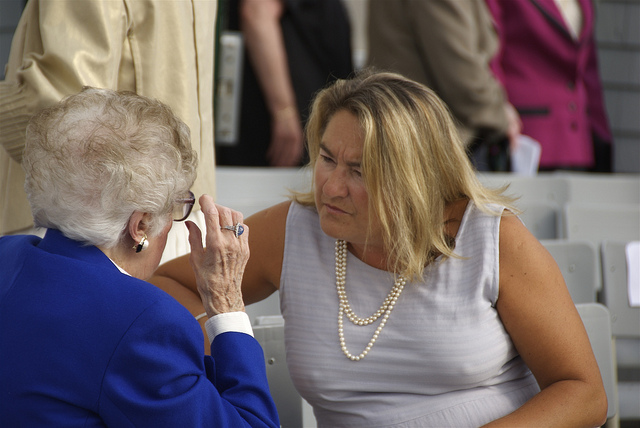 A woman listening intently to a story being told by a very elderly woman