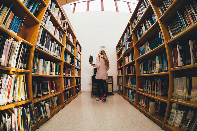 A woman doing research in a large library