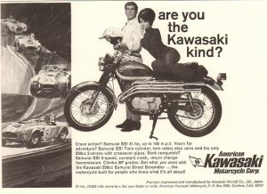 An advertisement for Kawasaki motorcycles from the 1970's. The slogan is "Are You the Kawasaki Kind?" The ad features an average looking man dressed in a shirt and tie standing behind a Kawasaki motorcycle and holding a motorcycle helmet. An attractive woman sits on the seat of the motorcycle and leans her head on the man's shoulder. " title="An advertisement for Kawasaki motorcycles from the 1970's. The slogan is "Are You the Kawasaki Kind?" The ad features an average looking man dressed in a shirt and tie standing behind a Kawasaki motorcycle and holding a motorcycle helmet. An attractive woman sits on the seat of the motorcycle and leans her head on the man's shoulder.