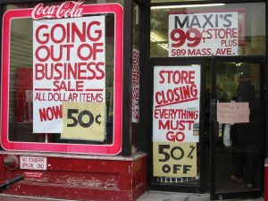 "Going out of Business" signs and "50% Off" signs outside a dollar store.